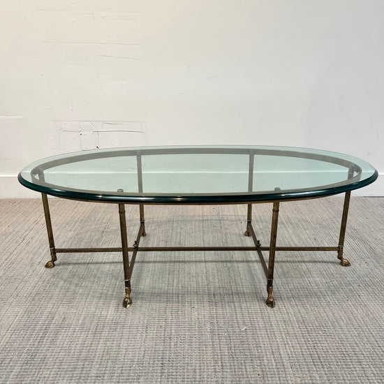 **MCM Brass oval glass coffee table by Labarge with brass hoof feet, 51ʺW × 26.5ʺD × 16.75ʺH